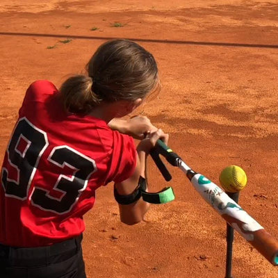 youth female player swinging a baseball bat with a swingrail